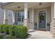 Inviting front porch featuring classic columns, brick accents, seating, and a charming front door at 3940 Frasier Dr, Cumming, GA 30028