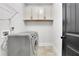 Functional laundry room with modern washer and dryer, ample cabinet storage and tiled floor at 3940 Frasier Dr, Cumming, GA 30028