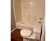 Bathroom with a white shower-tub and a toilet over brown tile flooring at 519 Roy Sw St, Atlanta, GA 30310
