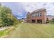 Spacious backyard with lush green grass and a view of the home's rear exterior at 5960 Overlook Club Cir, Suwanee, GA 30024