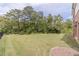 Large backyard featuring a well-maintained lawn and mature trees at 5960 Overlook Club Cir, Suwanee, GA 30024