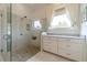 Elegant bathroom with glass shower enclosure, pebble floor, and white cabinets with marble countertop at 5960 Overlook Club Cir, Suwanee, GA 30024