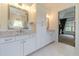 Bathroom featuring double vanity with marble countertop, white cabinets and access to the main bedroom at 5960 Overlook Club Cir, Suwanee, GA 30024