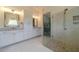 Bright bathroom features a glass shower with pebble floor and white cabinets for a clean, modern aesthetic at 5960 Overlook Club Cir, Suwanee, GA 30024