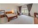 Spacious bedroom featuring a patterned carpet, cozy reading chair and large window at 5960 Overlook Club Cir, Suwanee, GA 30024
