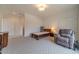 Comfortable bedroom with patterned carpet, reading chair, and ample closet space at 5960 Overlook Club Cir, Suwanee, GA 30024