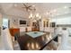 Open-concept dining room boasts elegant chandelier, seamlessly connecting to the living room and modern kitchen at 5960 Overlook Club Cir, Suwanee, GA 30024