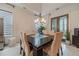 Elegant dining room with a modern chandelier, large windows, and a dark wood dining table at 5960 Overlook Club Cir, Suwanee, GA 30024