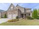 Charming two-story home featuring a manicured lawn, stone accents, and a welcoming front porch at 5960 Overlook Club Cir, Suwanee, GA 30024