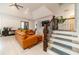 Spacious living room with hardwood floors, a staircase, and a plush orange sectional sofa at 5960 Overlook Club Cir, Suwanee, GA 30024