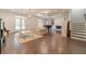 Spacious living room featuring hardwood floors, a grand piano, and a cozy fireplace at 5960 Overlook Club Cir, Suwanee, GA 30024