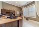 Bright home office features custom built-ins, a spacious desk, and a large window with blinds at 5960 Overlook Club Cir, Suwanee, GA 30024