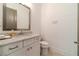Powder room featuring vanity with marble countertop, mirror, and toilet at 5960 Overlook Club Cir, Suwanee, GA 30024