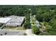 Aerial view of the neighborhood, with mature trees, houses, and a nearby building with parking at 2039 Gober Ave Se, Smyrna, GA 30080