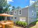 The backyard is enhanced with a wooden dining table, an umbrella, and potted plants at 2039 Gober Ave Se, Smyrna, GA 30080
