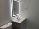 Modern bathroom featuring a gray vanity, illuminated mirror, and sleek fixtures at 2039 Gober Ave Se, Smyrna, GA 30080