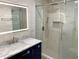 Modern bathroom featuring a glass shower, vanity with marble countertop and an illuminated mirror at 2039 Gober Ave Se, Smyrna, GA 30080