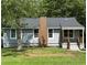 Charming home featuring a brick chimney, gray siding, a covered front porch, and a well-maintained lawn at 2039 Gober Ave Se, Smyrna, GA 30080