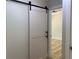 Hallway view features a white sliding barn door with black hardware, and bright light at 2039 Gober Ave Se, Smyrna, GA 30080