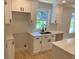 Bright kitchen features new white cabinets, quartz counters, updated fixtures and a window overlooking the backyard at 2039 Gober Ave Se, Smyrna, GA 30080
