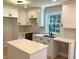 Bright kitchen features new white cabinets, island, quartz counters, updated fixtures and a window overlooking the backyard at 2039 Gober Ave Se, Smyrna, GA 30080