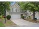 Two-story home with gray siding, white trim, two-car garage, and landscaped front yard on a sunny day at 3347 Sable Run Rd, Atlanta, GA 30349