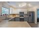 Modern kitchen with stainless steel appliances, stone countertops, gray cabinets, and ample natural light at 3347 Sable Run Rd, Atlanta, GA 30349