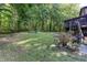 Expansive backyard featuring mature trees, open green space, and outdoor seating area for entertaining at 3470 Hill Ln, Acworth, GA 30102