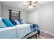 Comfortable bedroom featuring a bed with blue pillows, a ceiling fan, and a closet with double doors at 3470 Hill Ln, Acworth, GA 30102