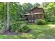 Charming home exterior featuring wood siding, a lush green lawn, and mature trees at 3470 Hill Ln, Acworth, GA 30102