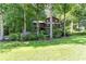 Two-story home with brown siding, front porch, and surrounded by mature trees at 3470 Hill Ln, Acworth, GA 30102