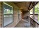 Covered porch with wood flooring, siding, and views of the surrounding trees at 3470 Hill Ln, Acworth, GA 30102
