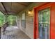 Covered porch featuring a vibrant red front door and natural outdoor scenery at 3470 Hill Ln, Acworth, GA 30102