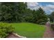 Picturesque backyard with a well-manicured lawn, mature trees, and ample space for recreation and relaxation at 388 Rose Creek Pl, Woodstock, GA 30189