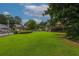 Lush green backyard showcasing the house, a spacious lawn, perfect for relaxation or recreational activities at 388 Rose Creek Pl, Woodstock, GA 30189