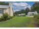 The backyard features a lush lawn, professional landscaping, and a rustic wooden fence at 388 Rose Creek Pl, Woodstock, GA 30189