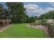 Picture of a large, meticulously maintained lawn with mature trees and an outdoor seating area at 388 Rose Creek Pl, Woodstock, GA 30189