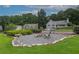 Charming backyard firepit with gravel, natural stone border, mature landscaping, and inviting chairs for cozy gatherings at 388 Rose Creek Pl, Woodstock, GA 30189