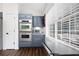 A kitchen showcases stainless steel double ovens, microwave, and gray cabinets under a bright window at 388 Rose Creek Pl, Woodstock, GA 30189