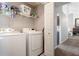 Laundry room with washer, dryer, shelving, and view into living room at 388 Rose Creek Pl, Woodstock, GA 30189