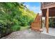 Multi-level backyard featuring a deck, brick patio, and stairs leading to a grassy area surrounded by mature trees at 109 Hale View Cir, Canton, GA 30114