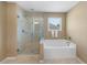 Bright bathroom featuring a glass enclosed shower and a soaking tub near a window at 109 Hale View Cir, Canton, GA 30114