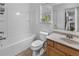 Bathroom with a tub/shower combination, oak vanity, and window for natural light at 109 Hale View Cir, Canton, GA 30114