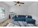 Cozy living room featuring a comfortable blue sectional sofa, plush carpet, and a bright window for natural light at 109 Hale View Cir, Canton, GA 30114