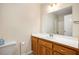 Neutral bathroom featuring a wooden vanity with white top, and large mirror at 3255 Marine Rd, Cumming, GA 30041
