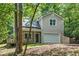 Home with a one-car garage and cozy front porch, framed by lush trees and natural landscaping at 3255 Marine Rd, Cumming, GA 30041