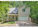 Charming home featuring a one-car garage and a cozy front porch, surrounded by lush trees at 3255 Marine Rd, Cumming, GA 30041