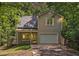 Charming home featuring a one-car garage and a cozy front porch, surrounded by lush trees at 3255 Marine Rd, Cumming, GA 30041