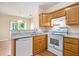 Well-lit kitchen with wood cabinets, granite countertops, and modern appliances for easy cooking at 3255 Marine Rd, Cumming, GA 30041