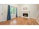 Bright living room with a fireplace, hardwood floors, large window, and staircase at 3255 Marine Rd, Cumming, GA 30041